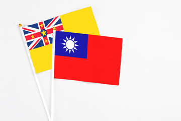Taiwan and Niue stick flags on white background. High quality fabric, miniature national flag. Peaceful global concept.White floor for copy space.