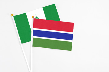 Gambia and Norfolk Island stick flags on white background. High quality fabric, miniature national flag. Peaceful global concept.White floor for copy space.