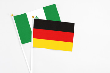 Germany and Norfolk Island stick flags on white background. High quality fabric, miniature national flag. Peaceful global concept.White floor for copy space.