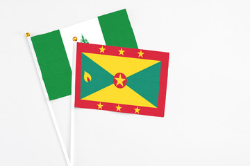 Grenada and Norfolk Island stick flags on white background. High quality fabric, miniature national flag. Peaceful global concept.White floor for copy space.