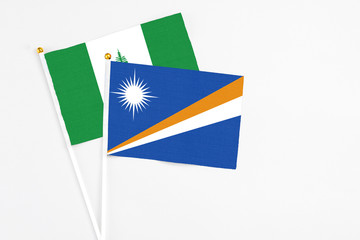 Marshall Islands and Norfolk Island stick flags on white background. High quality fabric, miniature national flag. Peaceful global concept.White floor for copy space.