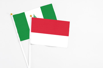 Monaco and Norfolk Island stick flags on white background. High quality fabric, miniature national flag. Peaceful global concept.White floor for copy space.