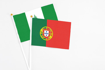 Portugal and Norfolk Island stick flags on white background. High quality fabric, miniature national flag. Peaceful global concept.White floor for copy space.