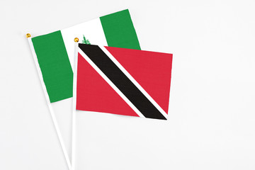 Trinidad And Tobago and Norfolk Island stick flags on white background. High quality fabric, miniature national flag. Peaceful global concept.White floor for copy space.