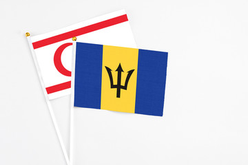 Barbados and Northern Cyprus stick flags on white background. High quality fabric, miniature national flag. Peaceful global concept.White floor for copy space.