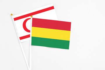 Bolivia and Northern Cyprus stick flags on white background. High quality fabric, miniature national flag. Peaceful global concept.White floor for copy space.