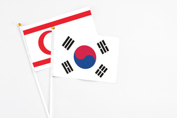 South Korea and Northern Cyprus stick flags on white background. High quality fabric, miniature national flag. Peaceful global concept.White floor for copy space.