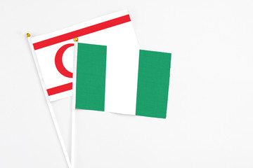 Nigeria and Northern Cyprus stick flags on white background. High quality fabric, miniature national flag. Peaceful global concept.White floor for copy space.
