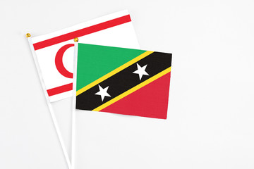 Saint Kitts And Nevis and Northern Cyprus stick flags on white background. High quality fabric, miniature national flag. Peaceful global concept.White floor for copy space.