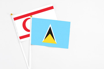 Saint Lucia and Northern Cyprus stick flags on white background. High quality fabric, miniature national flag. Peaceful global concept.White floor for copy space.