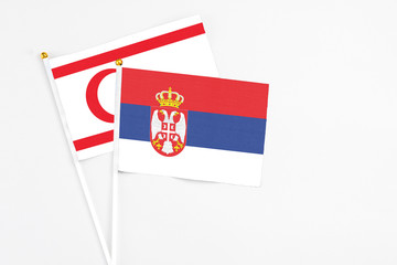 Serbia and Northern Cyprus stick flags on white background. High quality fabric, miniature national flag. Peaceful global concept.White floor for copy space.