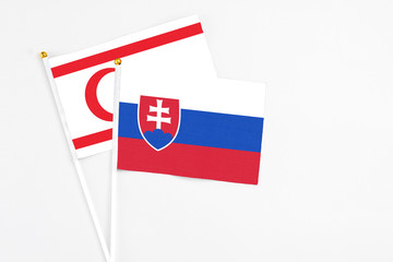 Slovakia and Northern Cyprus stick flags on white background. High quality fabric, miniature national flag. Peaceful global concept.White floor for copy space.