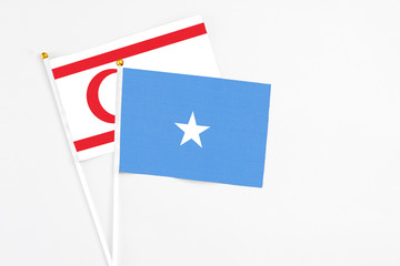 Somalia and Northern Cyprus stick flags on white background. High quality fabric, miniature national flag. Peaceful global concept.White floor for copy space.
