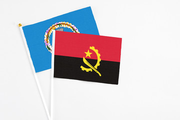 Angola and Northern Mariana Islands stick flags on white background. High quality fabric, miniature national flag. Peaceful global concept.White floor for copy space.