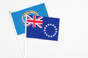 Fototapeta premium Cook Islands and Northern Mariana Islands stick flags on white background. High quality fabric, miniature national flag. Peaceful global concept.White floor for copy space.