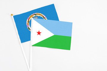 Djibouti and Northern Mariana Islands stick flags on white background. High quality fabric, miniature national flag. Peaceful global concept.White floor for copy space.