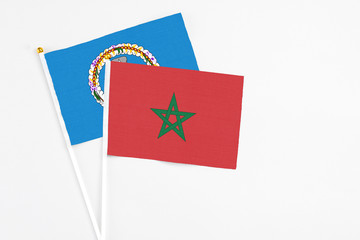 Morocco and Northern Mariana Islands stick flags on white background. High quality fabric, miniature national flag. Peaceful global concept.White floor for copy space.