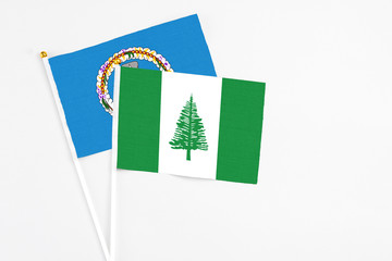 Norfolk Island and Northern Mariana Islands stick flags on white background. High quality fabric, miniature national flag. Peaceful global concept.White floor for copy space.