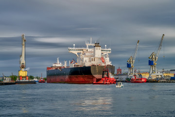 large cargo ship, assisted by tugs, enters the port. Gdansk. Poland