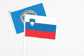 Slovenia and Northern Mariana Islands stick flags on white background. High quality fabric, miniature national flag. Peaceful global concept.White floor for copy space.