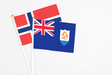 Anguilla and Norway stick flags on white background. High quality fabric, miniature national flag. Peaceful global concept.White floor for copy space.