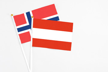 Austria and Norway stick flags on white background. High quality fabric, miniature national flag. Peaceful global concept.White floor for copy space.