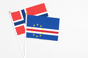 Cape Verde and Norway stick flags on white background. High quality fabric, miniature national flag. Peaceful global concept.White floor for copy space.