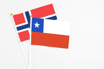 Chile and Norway stick flags on white background. High quality fabric, miniature national flag. Peaceful global concept.White floor for copy space.