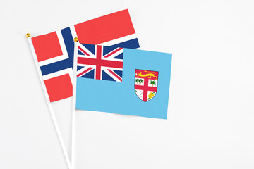 Fiji and Norway stick flags on white background. High quality fabric, miniature national flag. Peaceful global concept.White floor for copy space.