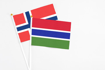 Gambia and Norway stick flags on white background. High quality fabric, miniature national flag. Peaceful global concept.White floor for copy space.