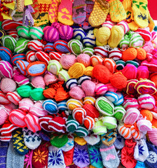 Fototapeta na wymiar Colorful handmade socks and mittens on stalls at Christmas market in Riga of Latvia winter. Street Xmas and holiday fair in European city or town. Advent Decoration with Crafts Items on Bazaar