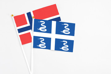 Martinique and Norway stick flags on white background. High quality fabric, miniature national flag. Peaceful global concept.White floor for copy space.