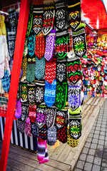 Handmade souvenirs knitted gloves on stalls at Christmas market in Riga of Latvia winter. Street Xmas and holiday fair in European city or town. Advent Decoration with Crafts Items on Bazaar