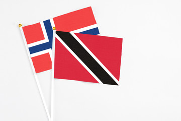 Trinidad And Tobago and Norway stick flags on white background. High quality fabric, miniature national flag. Peaceful global concept.White floor for copy space.