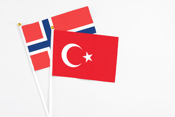 Turkey and Norway stick flags on white background. High quality fabric, miniature national flag. Peaceful global concept.White floor for copy space.