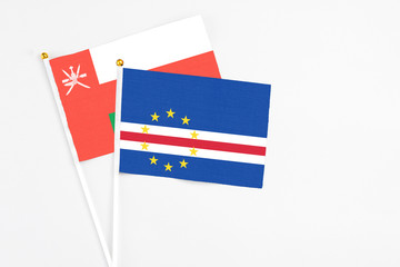 Cape Verde and Oman stick flags on white background. High quality fabric, miniature national flag. Peaceful global concept.White floor for copy space.