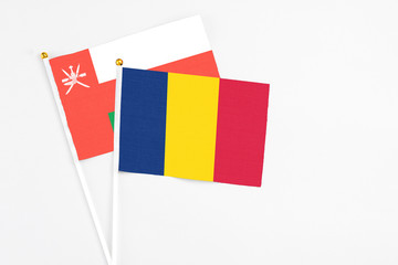 Chad and Oman stick flags on white background. High quality fabric, miniature national flag. Peaceful global concept.White floor for copy space.