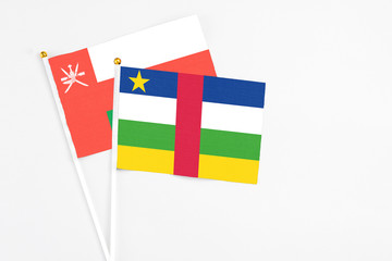 Central African Republic and Oman stick flags on white background. High quality fabric, miniature national flag. Peaceful global concept.White floor for copy space.