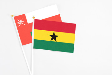 Ghana and Oman stick flags on white background. High quality fabric, miniature national flag. Peaceful global concept.White floor for copy space.