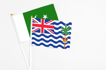 Fototapeta premium British Indian Ocean Territory and Pakistan stick flags on white background. High quality fabric, miniature national flag. Peaceful global concept.White floor for copy space.