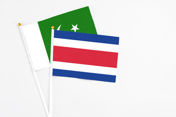 Costa Rica and Pakistan stick flags on white background. High quality fabric, miniature national flag. Peaceful global concept.White floor for copy space.
