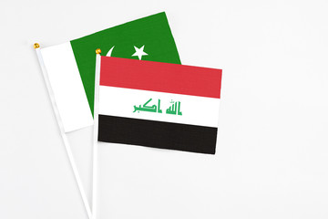 Iraq and Pakistan stick flags on white background. High quality fabric, miniature national flag. Peaceful global concept.White floor for copy space.