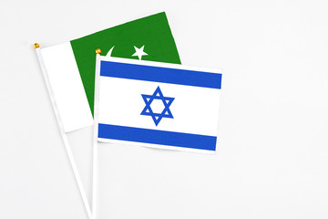 Israel and Pakistan stick flags on white background. High quality fabric, miniature national flag. Peaceful global concept.White floor for copy space.