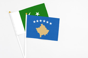 Kosovo and Pakistan stick flags on white background. High quality fabric, miniature national flag. Peaceful global concept.White floor for copy space.