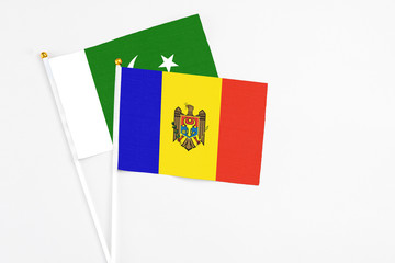 Moldova and Pakistan stick flags on white background. High quality fabric, miniature national flag. Peaceful global concept.White floor for copy space.