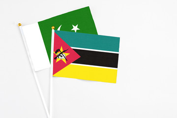 Mozambique and Pakistan stick flags on white background. High quality fabric, miniature national flag. Peaceful global concept.White floor for copy space.
