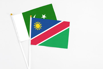 Namibia and Pakistan stick flags on white background. High quality fabric, miniature national flag. Peaceful global concept.White floor for copy space.