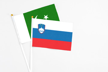 Slovenia and Pakistan stick flags on white background. High quality fabric, miniature national flag. Peaceful global concept.White floor for copy space.