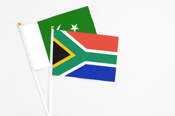 South Africa and Pakistan stick flags on white background. High quality fabric, miniature national flag. Peaceful global concept.White floor for copy space.