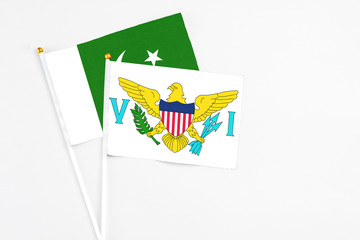 United States Virgin Islands and Pakistan stick flags on white background. High quality fabric, miniature national flag. Peaceful global concept.White floor for copy space.